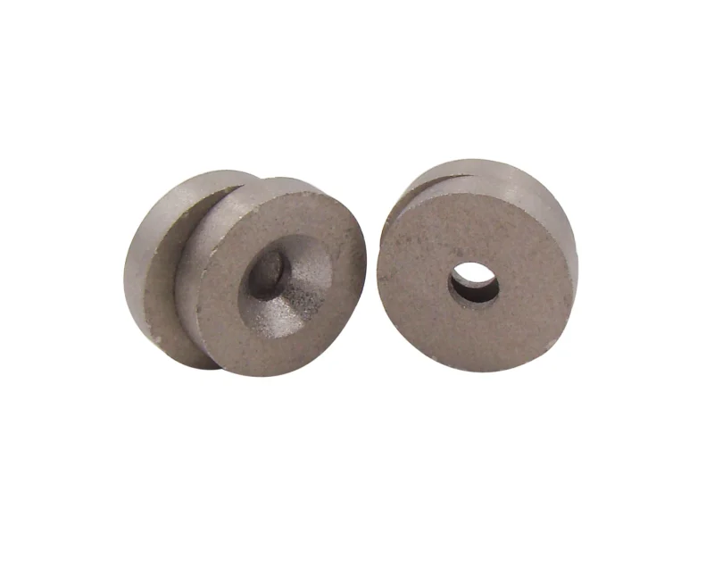 Four circular samarium cobalt magnets, showing the front and back respectively