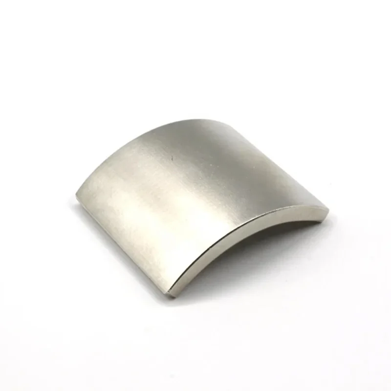 Single small neodymium magnet in arc shape, nickel - coated for electronics, showcasing N52 grade strength.