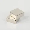 Two shiny N52 neodymium magnets (10×10×10mm square blocks, nickel - coated) stacked on a white background.