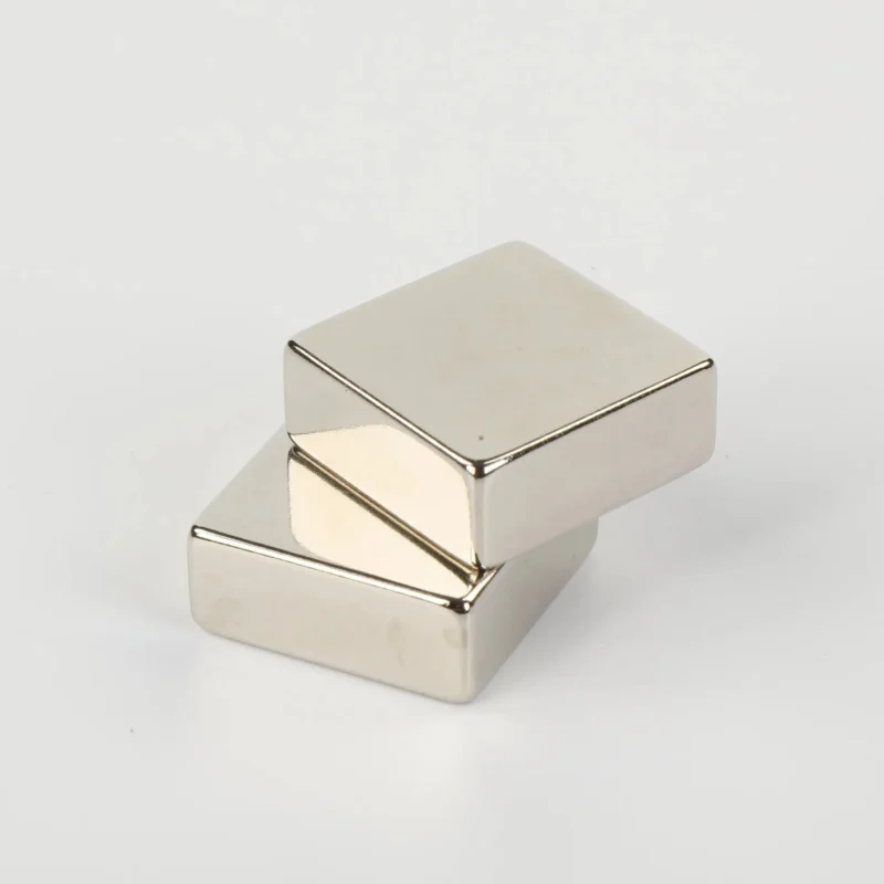 Two shiny N52 neodymium magnets (10×10×10mm square blocks, nickel - coated) stacked on a white background.