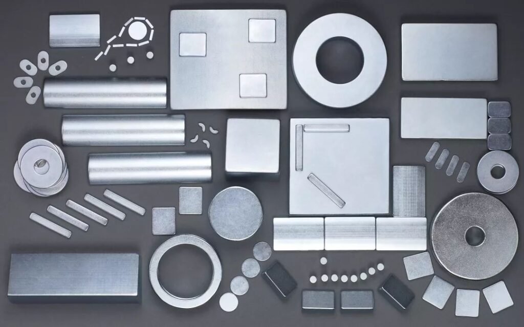 Various types of neodymium magnets displayed, including different shapes like bars, rings, discs, and irregular forms.