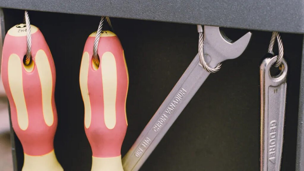 Magnetic hooks holding tools on a metal surface, showcasing secure storage with Magnetic Hooks.
