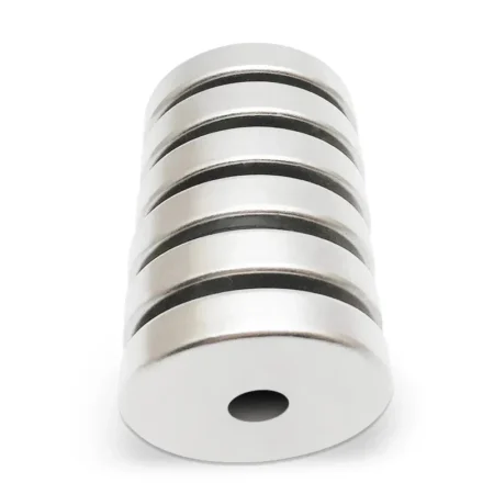 Stack of round N42 neodymium magnets showcasing magnetic attraction in industrial setup
