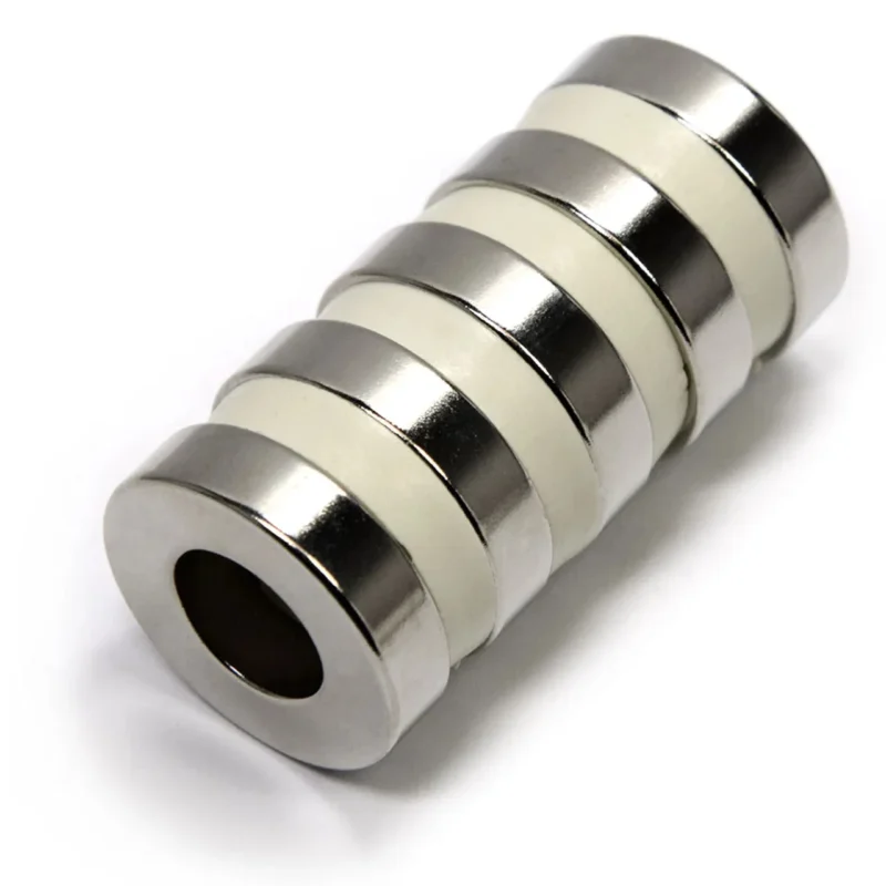 Single round N42 neodymium magnet highlighting nickel - coated, axially magnetized design