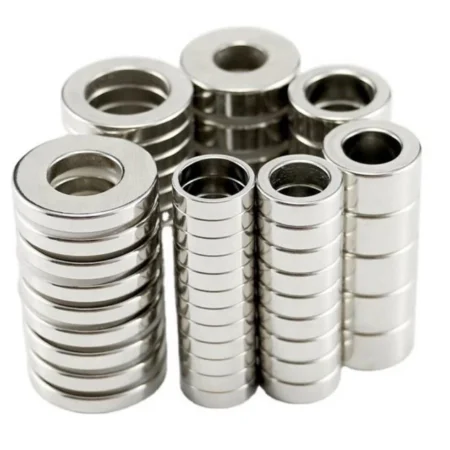 Assembly of tiny neodymium magnets in ring shape for electronic product integration, showcasing Ni - Cu - Ni coating.