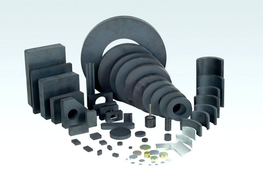 Diverse shapes of ferrite magnets, including rings, blocks, and custom forms, displayed on a light background