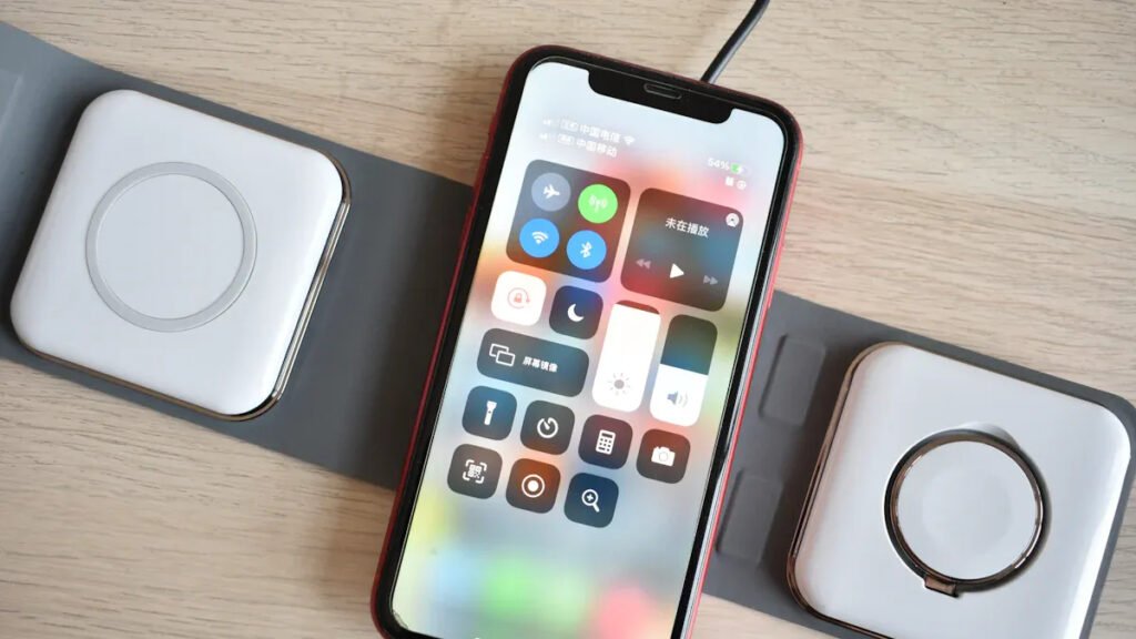 iPhone with MagSafe magnet ring placed on a dual - charger pad, demonstrating multi - device wireless charging